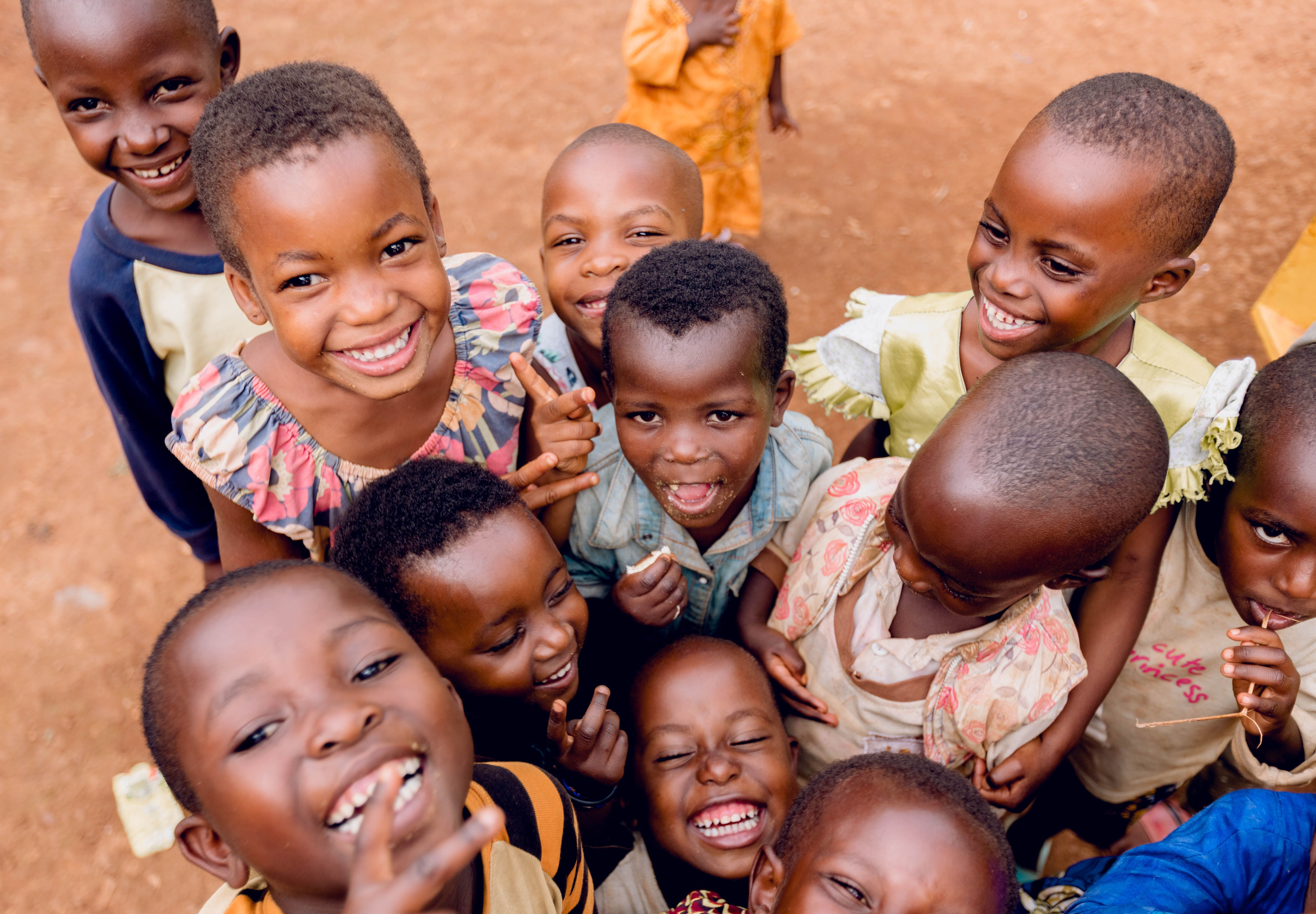 A group of children smiling outdoors in Kigali, Rwanda.
